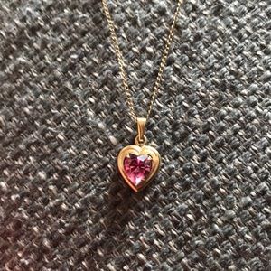Gold heart necklace with pink gem in center